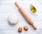 Raw Pizza Dough And Rolling Pin On Wooden Background Stock Photo