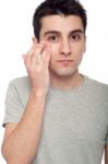 Young Man Applying Eye Cream Stock Photo