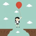 Business Concept, Business Woman Flies Across Gap To Another Cliff By Using Balloon Stock Photo