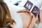 Pregnant Woman Looking At Ultrasound Scan Of Baby Stock Photo