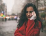 Sad News - Woman In Red Coat Hold On Mobile Phone Stock Photo
