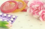 Pills And Condom On Carlendar Background With Soft Light Stock Photo