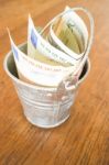 International Currencies Bank Note In The Bucket Stock Photo