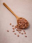 The Composition Of Raw Pinto Beans In Wooden Spoon On Brown Back Stock Photo