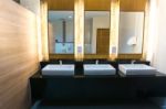 Commercial Bathroom With Three Sink And Mirror Stock Photo