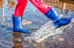 Girl Standing In A Puddle Of Water Splashes Stock Photo