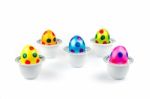 Painted Easter Eggs Standing In Porcelain Egg Cups On White Stock Photo