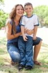 Image Of Caring Mother Embracing Her Son While At The Park Stock Photo