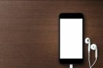 Phone Blank Screen And Headphone On Wood Table, Mockup New Phone Stock Photo