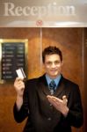 Male Receptionist Holding Cash Card Stock Photo