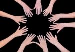 Five Children Hands Joining In Circle Above Black Background Stock Photo