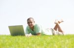 A Young Men Lying On The In The Park Using A Laptop Stock Photo