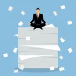 Businessman Meditating On A Lot Of Documents Stock Photo