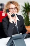 Front Desk Lady Attending Clients Call Stock Photo