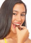 Young Girl Eating Chocolates Stock Photo