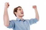 Young Man Celebrating Success With Arms Up Stock Photo