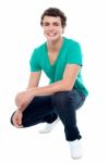 Smiling Young Male Squatting Down Stock Photo