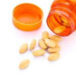 Closeup Of Orange Pills And Pill Bottle Stock Photo