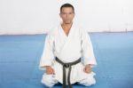 Black Belt Karate Man Sit On A Position To Start Or Finish Pract Stock Photo