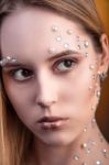 Girl With White And Pearl Rhinestones On Her Face Stock Photo