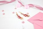Golden Hairpins With Pink Gemstone And Pink Ribbon On Pink Background Stock Photo