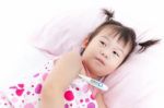 Little Girl Lying On Sickbed With Digital Thermometer In Her Armpit Stock Photo