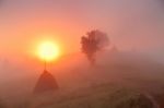 Sunrise Over Mountain Field. Haystacks In Misty Autumn Morning H Stock Photo