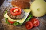 Close Up Of Ham Cheese Burger And Bun With Tomato Onion And Gree Stock Photo