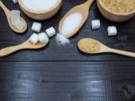 Wooden Bowl And Spoon With Sugar Cube On Dark Wood Background Stock Photo