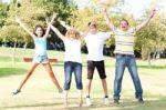 Family Jumping With Wide-spread Raised Arms Stock Photo