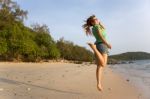 A Woman Jumping On A Beach Stock Photo