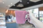 Women Hand Holding Mug With Blurred Cafe Stock Photo