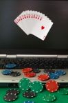 Poker Chips And Cards And A Laptop On Casino Baize Stock Photo