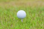 Golf Ball On Tee Over A Blurred Green Stock Photo