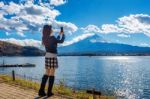 Woman Use Mobile Phone Take A Photo At Fuji Mountains, Kawaguchiko Lake In Japan Stock Photo