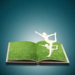 Paper Cut Of Girl Doing Yoga In Book Stock Photo