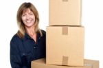 Cheerful Delivery Woman Carrying Sealed Cartons Stock Photo