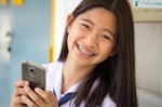Portrait Of Thai Student Teen Beautiful Girl Using Her Phone And Smile Stock Photo