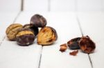 Hot Toasted Chestnuts On White Wooden Background Stock Photo