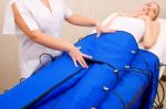 Legs Pressotherapy Machine On Woman In Beauty Center Stock Photo