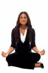Businesswoman Meditating In Lotus Posture Stock Photo