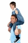 Confident Father Carrying His Son On Shoulder Stock Photo