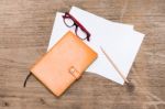 Orange Diary,blank Paper With Pencil And Eye Glasses On Wood Table Stock Photo