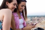 Beautiful Girls Sitting On The Roof And Listening To Music At Su Stock Photo