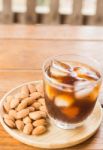 Glass Of Black Iced Coffee With Almond Grain Stock Photo