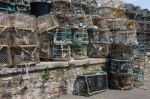 Lobster Pots Stacked Against The Harbour Wall In Brixham Stock Photo