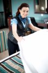 Lady Attendant Arranging Bed Sheet Stock Photo