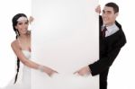 Bride And Groom Pointing At Blank Board Stock Photo
