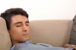 Man Sleeping On The Couch Stock Photo