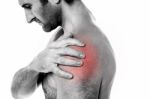 Closeup Of Young Man Having Pain In Shoulder Stock Photo